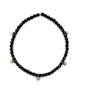 Gold bead charm stretch bracelet with black onyx faceted beads